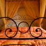 Particolare letto in ferro battuto con baldacchino